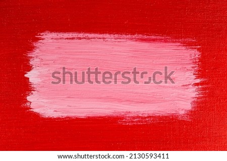 thick white acrylic paint applied in an uneven patch on a red surface 