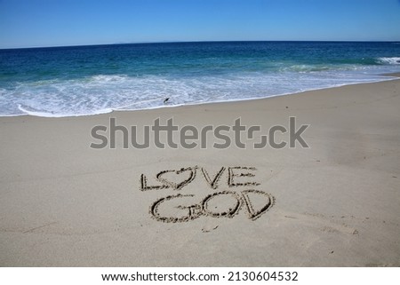 Gods Love. Love God. Words written in sand. The words LOVE GOD and GODS Love written in sand with the Ocean background. God Made the Oceans for all to enjoy and care for.  Royalty-Free Stock Photo #2130604532