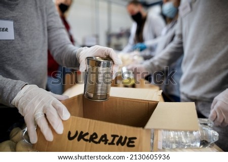 Group of volunteers collect donations for Ukrainian refugees, humanitarian aid concept. Royalty-Free Stock Photo #2130605936