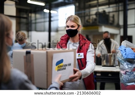 Volunteers collecting donations for the needs of Ukrainian migrants, humanitarian aid concept. Royalty-Free Stock Photo #2130606002