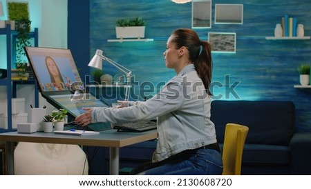 Woman photographer preparing for retouch work on pictures in photography studio. Media editor working with retouching app on computer and graphic tablet for image editing production