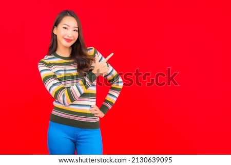 Portrait beautiful young asian woman smile with action on red isolated background