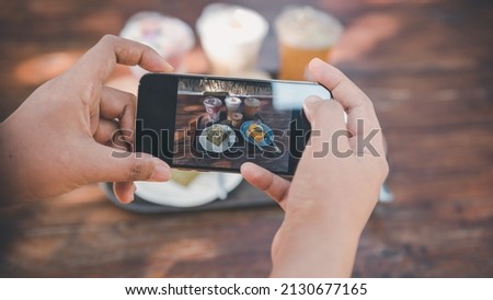 Woman Hands Taking Photographs Foods on Her Mobile Phone, Customer Woman Using Smartphone Take a Picture Food for Sharing Her Friends in Cafe and Restaurant Shop. Technology Digital Smart Phone