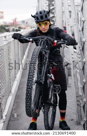 Young caucasian cyclist riding a bike at steel bridge