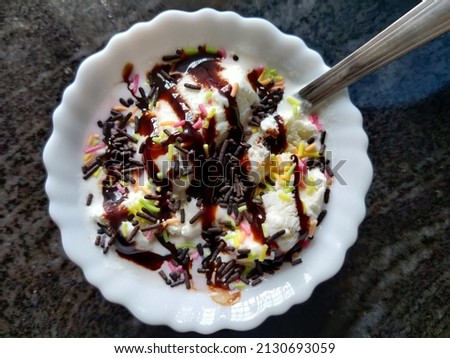 picture of ice-cream with a lot of chocolate syrup and rainbow sprinkles