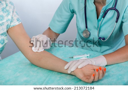 Doctor preparing patient's hand for an injection