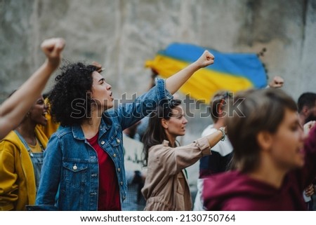 Crowd of activists protesting against Russian military invasion in Ukraine walking in street. Royalty-Free Stock Photo #2130750764
