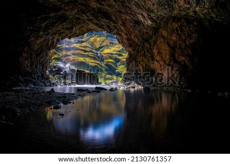 A cave in the mountain filled with water. Water in mountain cave. Mountain cave water flow. Water in cave