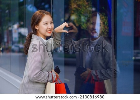 Asian woman holding shopping bags at a shopping center Happy shopping time