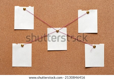 Blank paper notes are pinned to a cork board. The concept of detective investigation. Copy space. Royalty-Free Stock Photo #2130846416