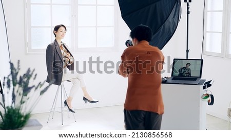 Photographer shooting photo of fashion model in the shooting studio. Royalty-Free Stock Photo #2130856568