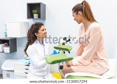 Gynecologist preparing for an examination procedure for a pregnant woman sitting on a gynecological chair in the office Royalty-Free Stock Photo #2130857294