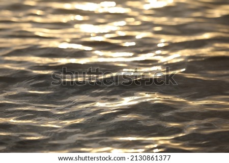texture of water wave with reflection of sunlight at sunset