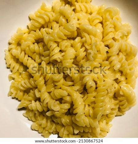 Amazing Cooked fusilli Italian pasta white and wooden background Image in close-up of raw fusilli pasta in white circle plate