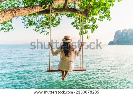 Traveler woman relaxing on swing above Andaman sea Railay beach Krabi, Leisure tourist travel Phuket Thailand summer holiday vacation trip, Beautiful destinations place Asia, Happy dream concept Royalty-Free Stock Photo #2130878285