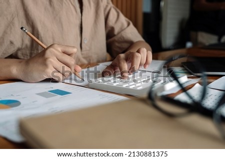 Close up business woman using calculator for do math finance on wooden desk in office and business working background, tax, accounting, statistics and analytic research concept