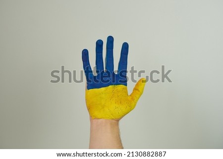 a man's hand painted in the colors of the flag of Ukraine