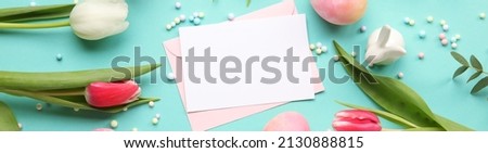 Beautiful composition with blank card, tulip flowers and Easter eggs on color background