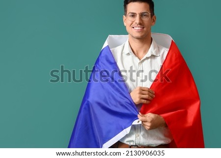 Handsome young man with flag of France on green background