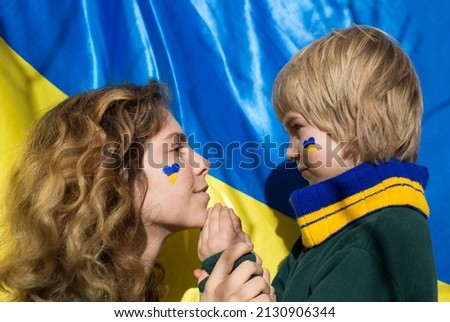 faces of boy and young woman with painted yellow-blue heart on cheeks. Family, unity, support. Ukrainians are against war. asking for help from world community. Caring for each other. Child are afraid Royalty-Free Stock Photo #2130906344