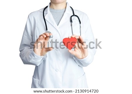 The doctor holds an ampoule with a clear liquid in one hand, and a red heart in the other hand. Medical concept, goiter, rescue, treatment.