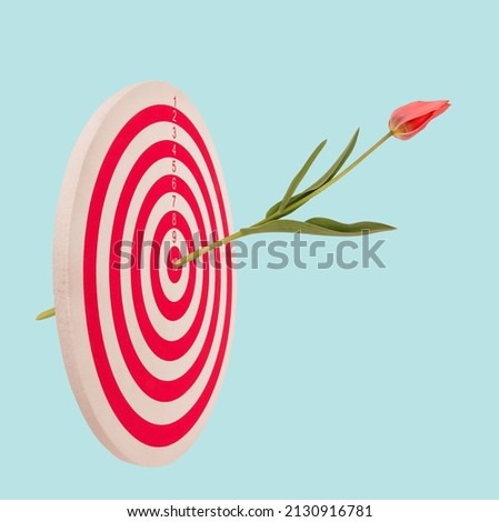 Target with beautiful tulip flower bud hit in center. Bullseye love goal concept.