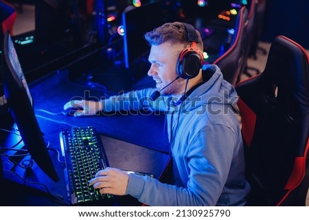 Professional cyber gamer studio room with personal computer armchair, keyboard for stream in neon color blur background. Concept esport vlog.