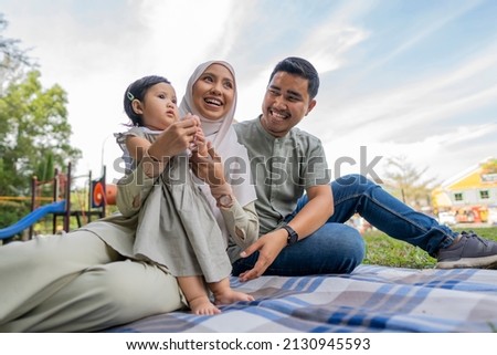 
Happy Muslim Family Have A Picnic Outdoor smiling to each other