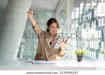 Pretty Asian businesswoman sitting on a laptop And the work came out successfully and the goal was achieved, happy and satisfied with her. Royalty-Free Stock Photo #2130946247