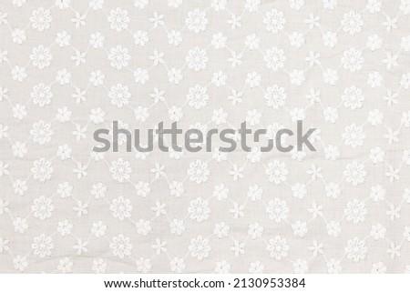 Flat white-colored lace fabric texture background. This fabric is made of 100% cotton. Royalty-Free Stock Photo #2130953384