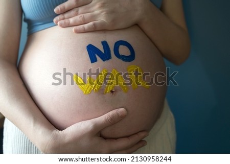 The War in Ukraine, Ukrainian conflict background. The Ukrainian flag is painting on the belly of a pregnant woman. Peace, pacifism, activism, no war and support concept