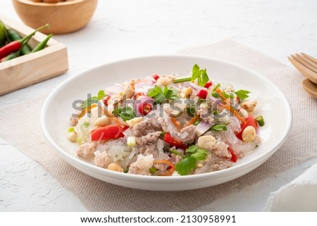 Spicy Glass Noodle Salad with Minced Pork (Yum woon sen) is a type of Thai salad made with clear bean vermicelli and meat in white plate Royalty-Free Stock Photo #2130958991
