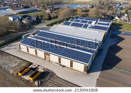 Drone photo of modern solar panels on a commercial building. Solar panels provide cheap solar energy. Royalty-Free Stock Photo #2130961808