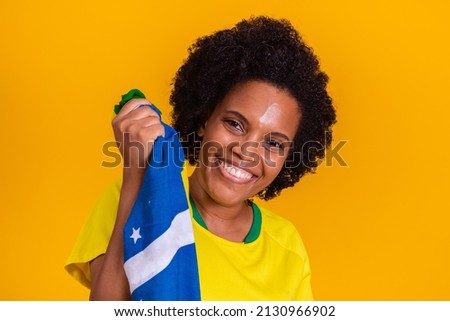 Brazilian female supporter taking a selfie with a brazilian flag in hands 