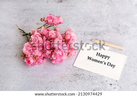 Happy Women's Day  Greeting Card with Pink Roses  on a Gray Textured  Background 