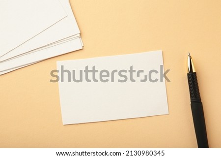 Blank white business cards on beige paper background. Mockup for branding identity. Template for graphic designers portfolios.