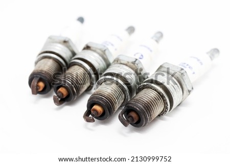 Used spark plugs of a crossover gasoline engine on a white background