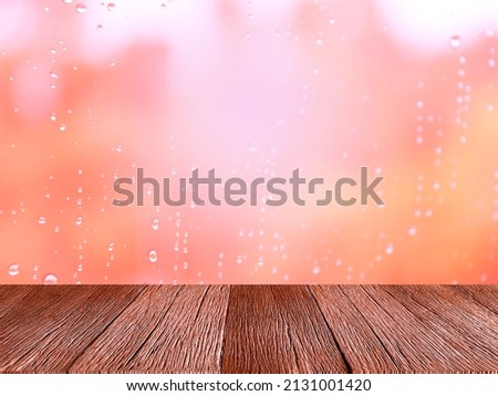 Empty wooden table for displaying products. 
On a rainy day, seeing a drop of water on the outer glass blurred (Background, rainy day window)
With copy space.
