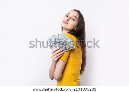 Photo of rich woman in simple clothes holding fan of dollar money isolated on white background