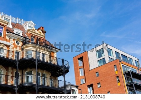Modern and new apartment building. Multistoried modern, new and stylish living block of flats in a coastal town Royalty-Free Stock Photo #2131008740