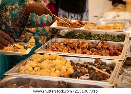 close-up of African food during a buffet at a party. Fried plantains, potatoes, meat and vegetables Royalty-Free Stock Photo #2131009016