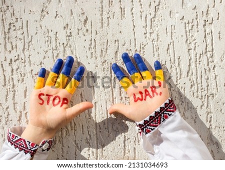 hands of a child in national clothes, painted in yellow - blue, the inscription STOP WAR. Russia's invasion of Ukraine, Children against the war. Military conflict with Russia.. Stand with Ukraine Royalty-Free Stock Photo #2131034693