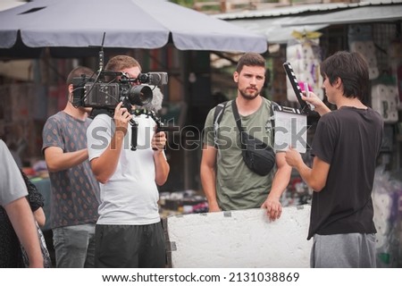 Behind the scenes. Film crew team shooting movie scene on outdoor location. Group filmmaking set production Royalty-Free Stock Photo #2131038869