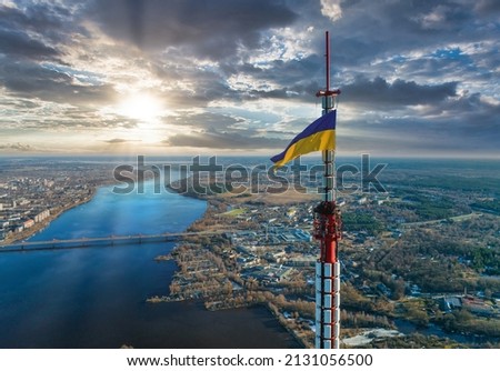 Aerial view of the Ukrainian flag waving on top of the Riga TV Tower in Latvia.