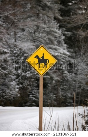 Yellow Caution Horse Riding Sign in a Rural Setting in Winter
