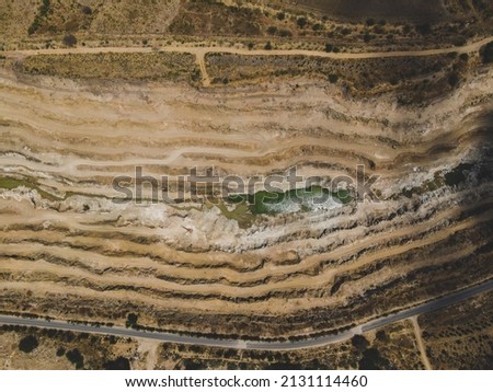 drone shot aerial view top angle photo of limestone mine quarry industry pattern background wallpaper bright sunny day india tamilnadu shadows mud roads semicircular 