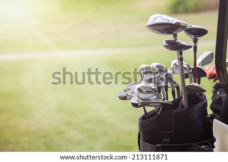 set of golf clubs over green field background Royalty-Free Stock Photo #213111871