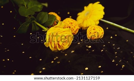 Yellow flowers on black background. Gerbera and rose on black veil with beads and decor