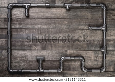 Frame. Background. Cast iron pipes and fittings of different shape, forming a frame on a rustic wooden table Royalty-Free Stock Photo #2131143311