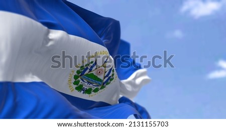 Detail of the national flag of El Salvador waving in the wind on a clear day. El Salvador is a country in Central America. Selective focus. Royalty-Free Stock Photo #2131155703